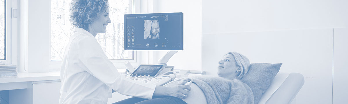 Ultraschalluntersuchung einer Schwangeren auf einer Behandlungsliege